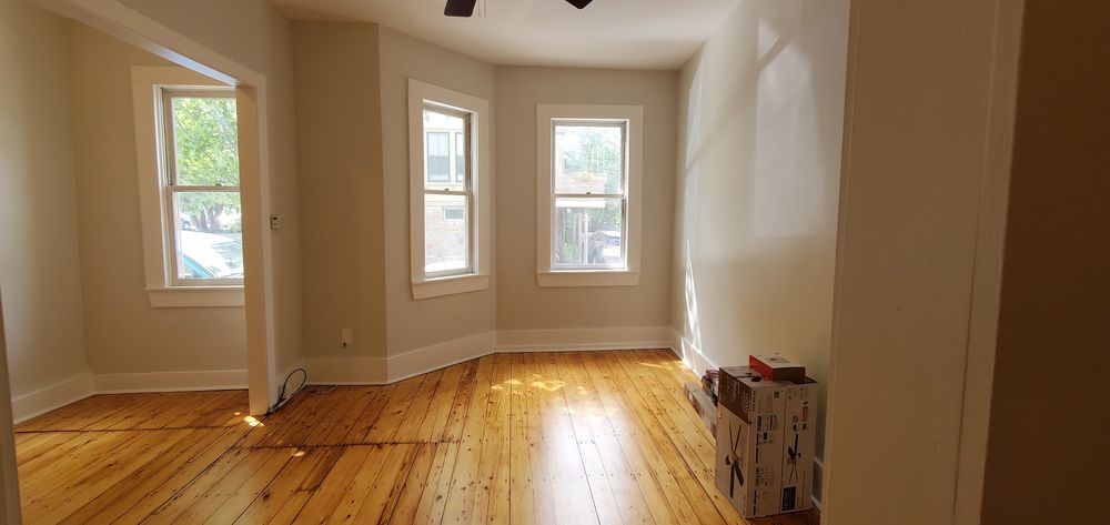 A rustic living room in New England with a warm, cozy atmosphere, featuring natural wood elements and a freshly painted finish by Impeccable Painting.