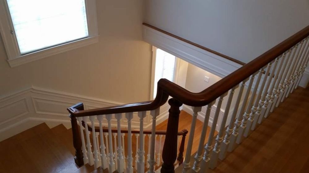 A beautifully painted stairwell with a clean, polished finish, showcasing the expert craftsmanship of Impeccable Painting.